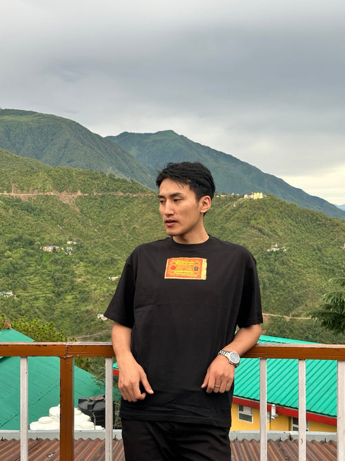 Black KHORLO Studio T-shirt featuring Tibetan Sang currency artwork